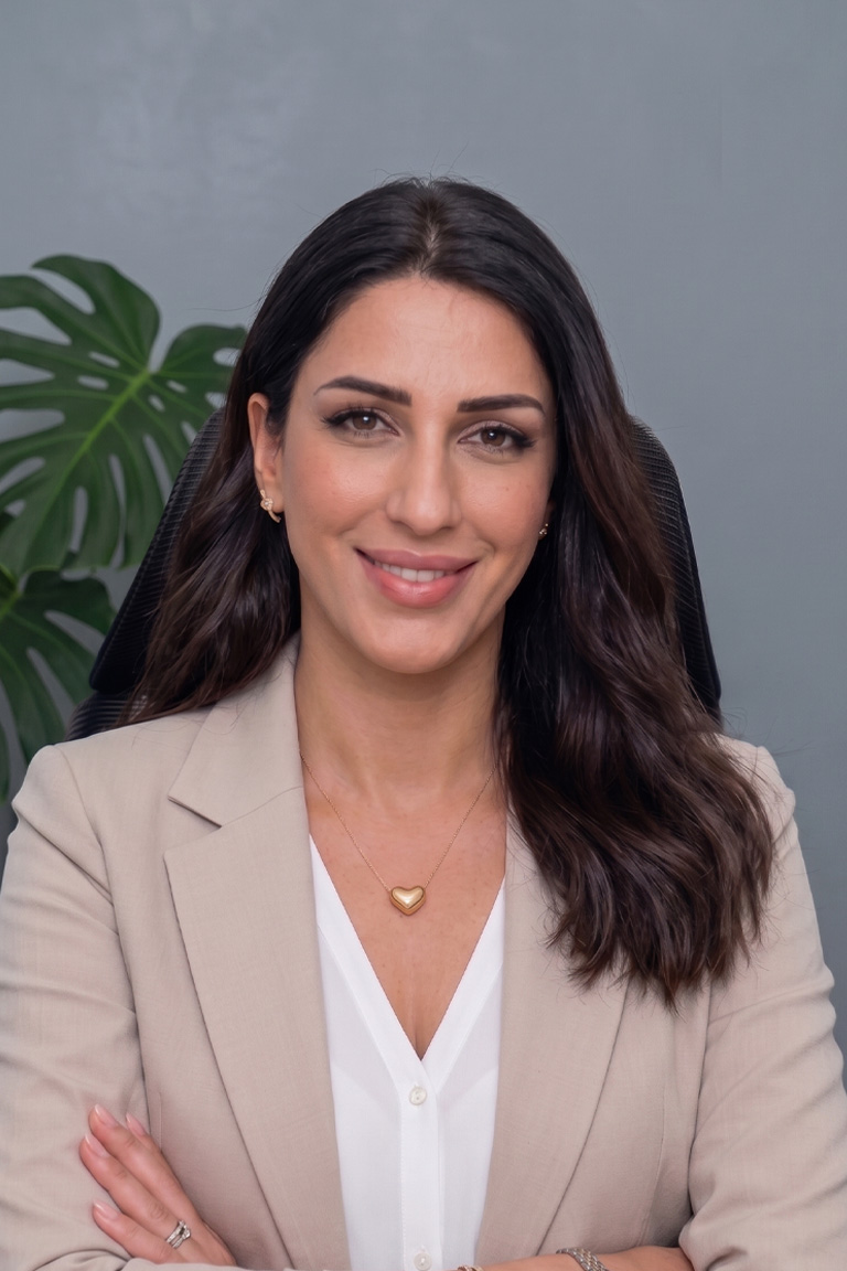Dr. Carole Saadé smiling, in a beige blazer